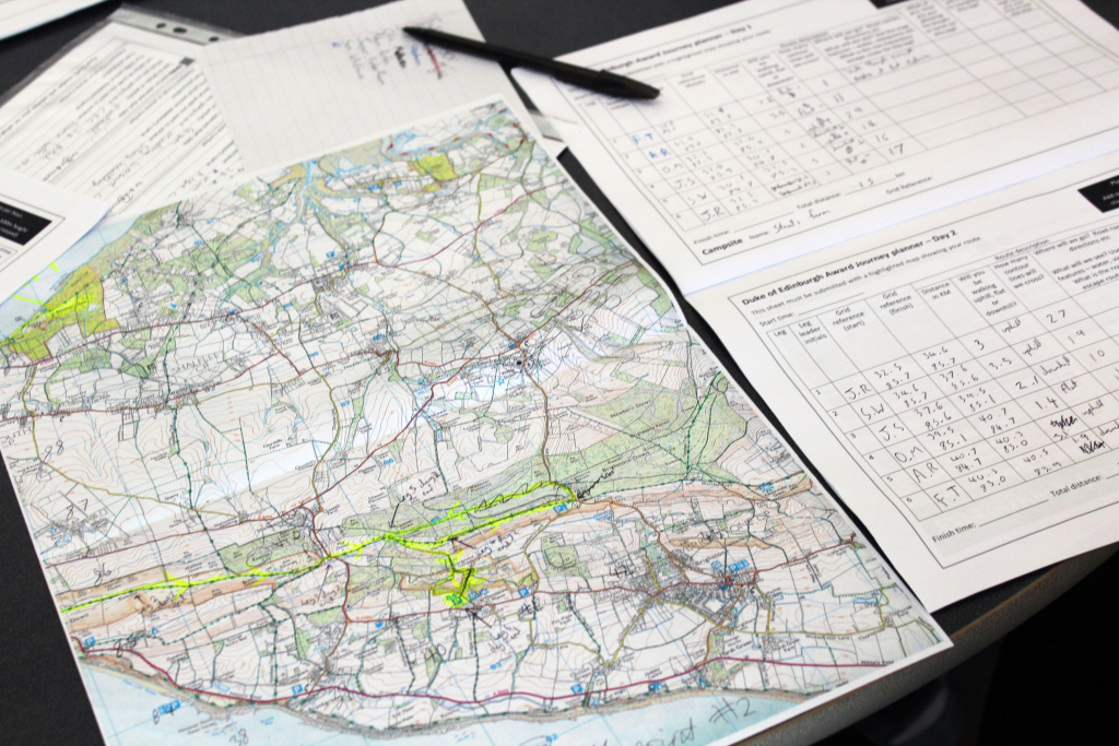 On the left, an ordinance survey map with highlights and anontations, on the right, page of a Duke of Edinburgh Award Journey Planner.