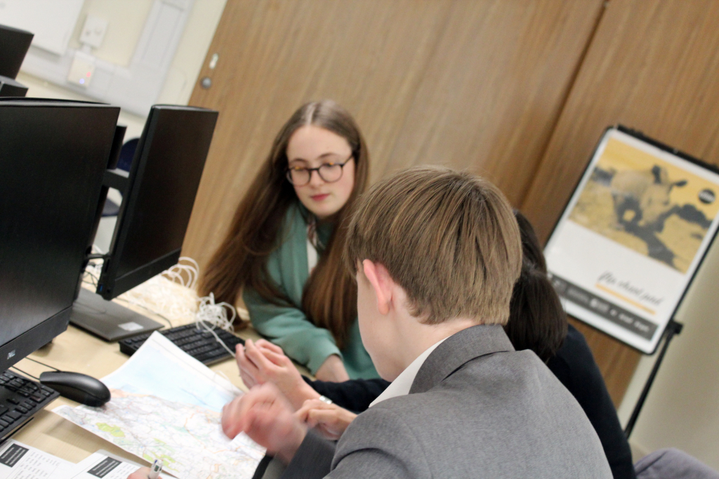 Sixth Form Student Leaders work with a students on Duke of Edinburgh Award walk planning using an ordinance survey map.